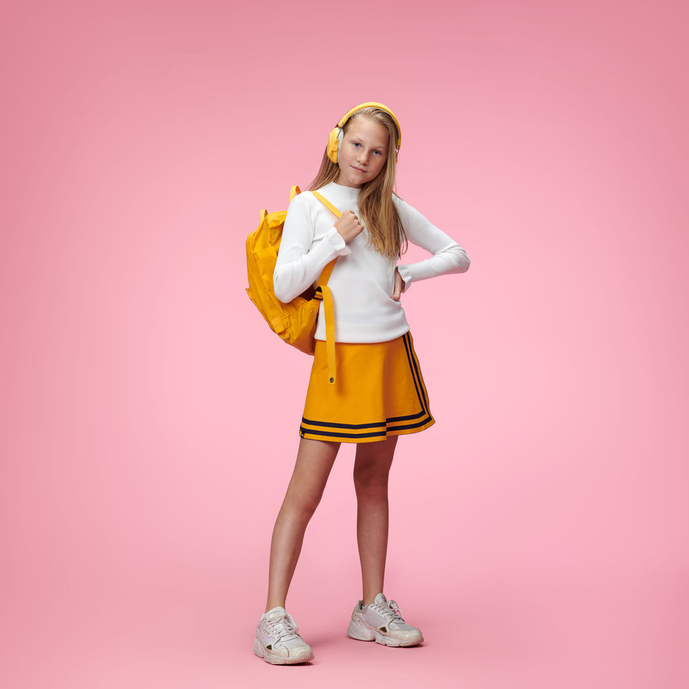 Girl in a yellow cheerleaders uniform wearing a yellow alpine earmuffs