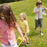 Three Children two girls and one boy who are a mixed of deaf and hard of hearings playing in the grss