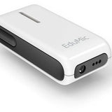 Oticon EduMic device lying flat, showcasing its compact, rectangular design with a white body and black side panel. The device has a visible button on the side and audio input ports on the front, next to the EduMic branding. It is designed to wirelessly transmit clear audio directly to hearing aids