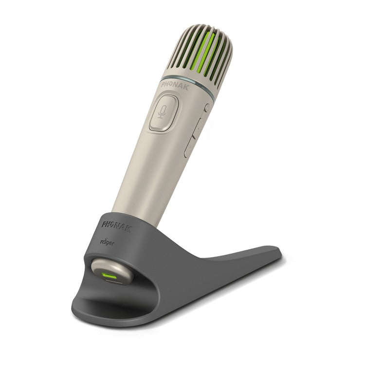 Phonak Roger Pass-around Microphone placed in its black charging stand, designed for classroom use with Roger SoundField systems to support inclusive audio and student participation.