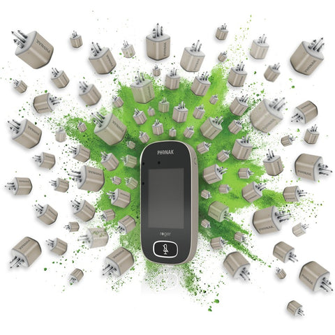 The image shows a Phonak Roger device in the center, surrounded by numerous hearing aid batteries. The batteries are scattered around, with a green splatter effect in the background, highlighting the central device. The batteries all display the Phonak logo. The device itself has a touchscreen and a microphone symbol on its front. The overall visual emphasizes the connection between the Roger device and the batteries